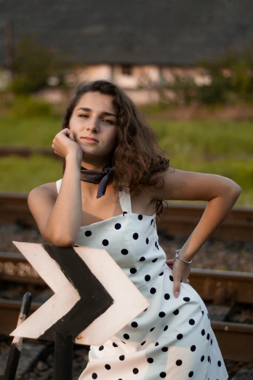 a beautiful young woman leaning on a train track