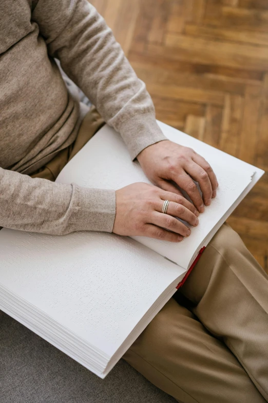 a man sitting on the floor holding a book, trending on pexels, perfectly drawn hands, elderly, lightly dressed, pastel'