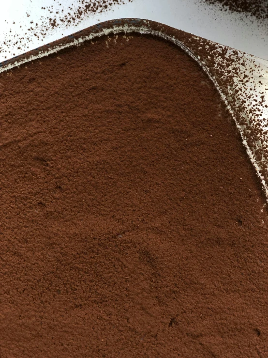 a piece of chocolate cake sitting on top of a table, powder, detailed product image, blending, zoomed in
