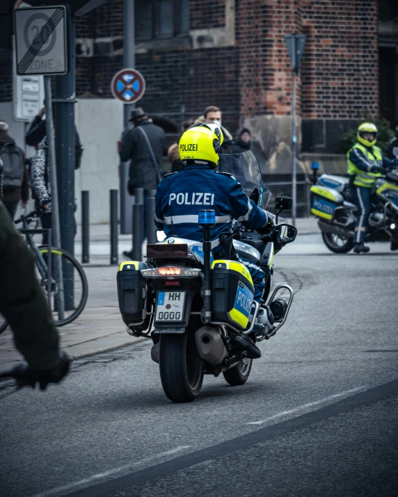 a man on a police motorcycle riding down the street