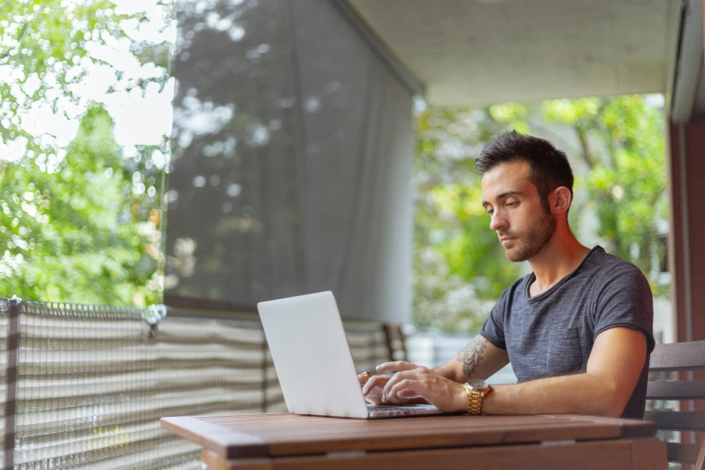 a man sitting at a table with a laptop, pexels, natural light outside, avatar image, high resolution image