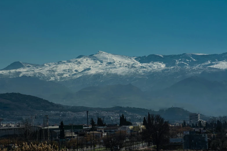 a mountain with snow covered mountains in the background