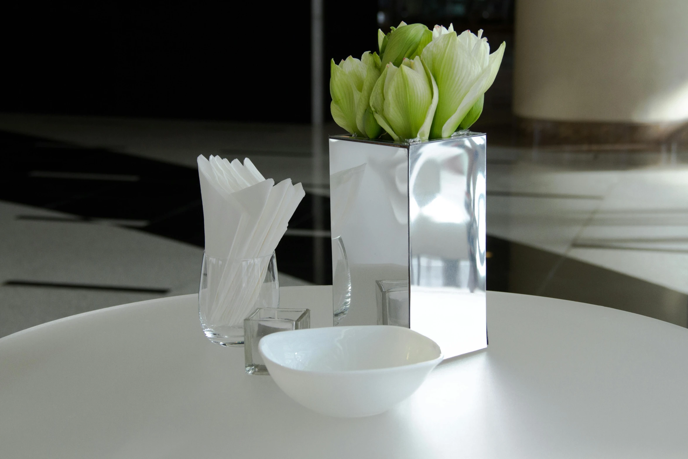 a small white vase filled with flowers on top of a table