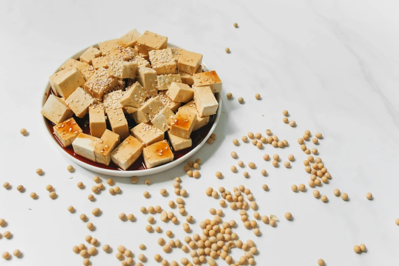 a bowl filled with tofu sitting on top of a table, food particles, caramel, detailed product image, frontal shot