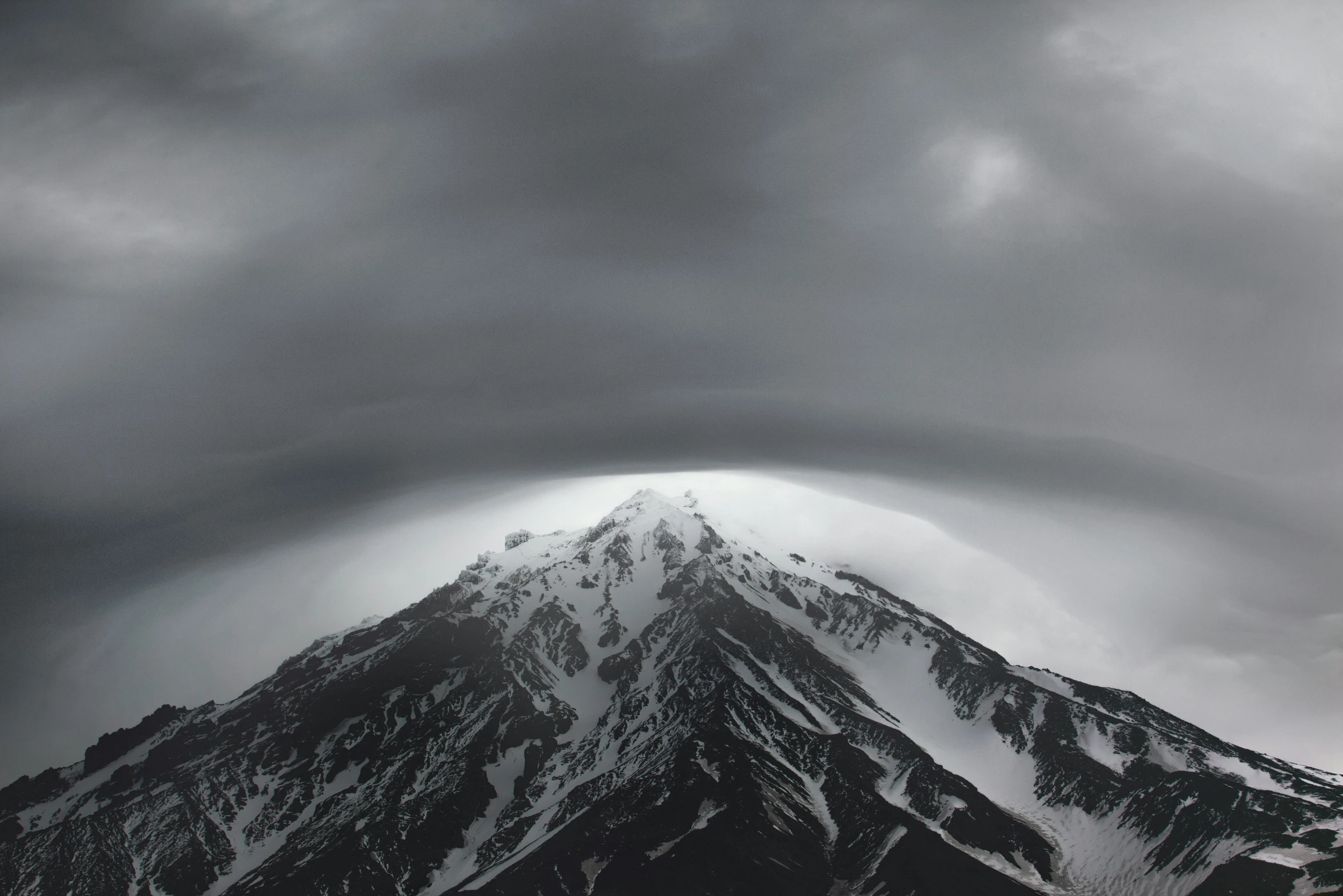 a large snowy mountain under a cloudy sky