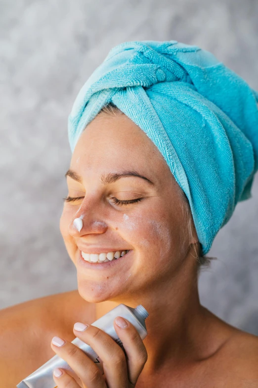 a woman with a towel on her head brushing her teeth, by Julian Allen, trending on pexels, synthetic bio skin, water spray, square facial structure, woman with hat