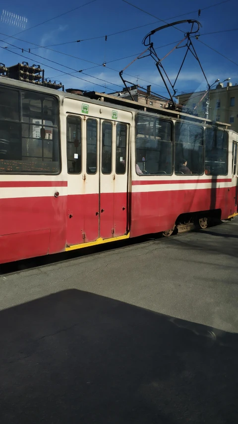 a red and white train traveling down train tracks, by Petr Brandl, instagram, street tram, low quality photo, under repairs, brown