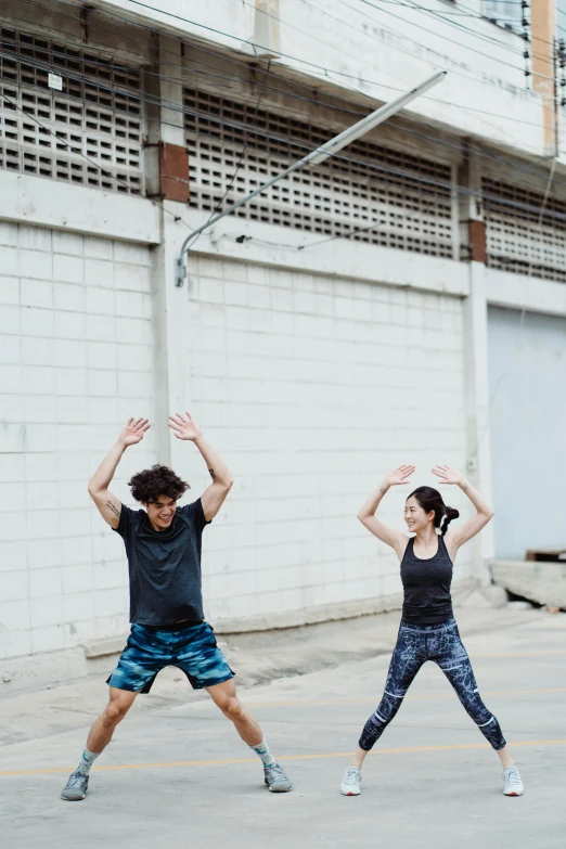 a couple of people that are standing in the street, stretching to walls, joy ang, working out, plain background