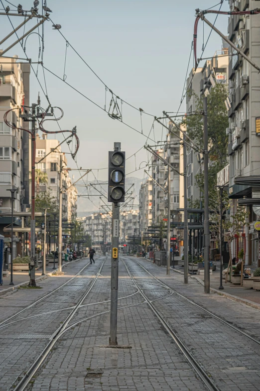 a street filled with lots of traffic next to tall buildings, art nouveau, electric cables, greece, 2022 photograph, early morning