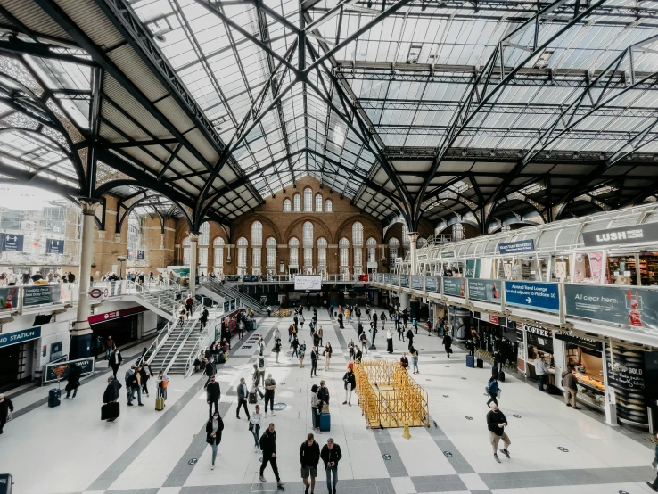 a group of people walking through a train station, inspired by Thomas Struth, pexels contest winner, wrought iron architecture, 🚿🗝📝, square, aerial