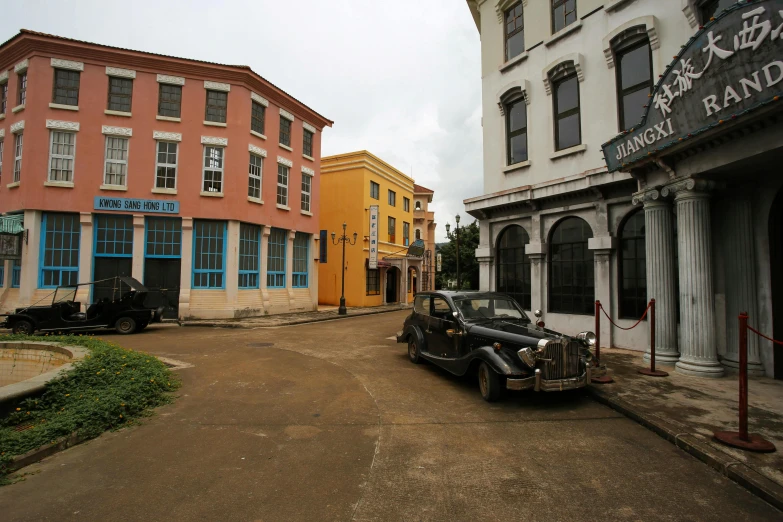 an old car parked in front of a building, bengal school of art, movie still 8 k, replica model, houses and buildings, ingame image