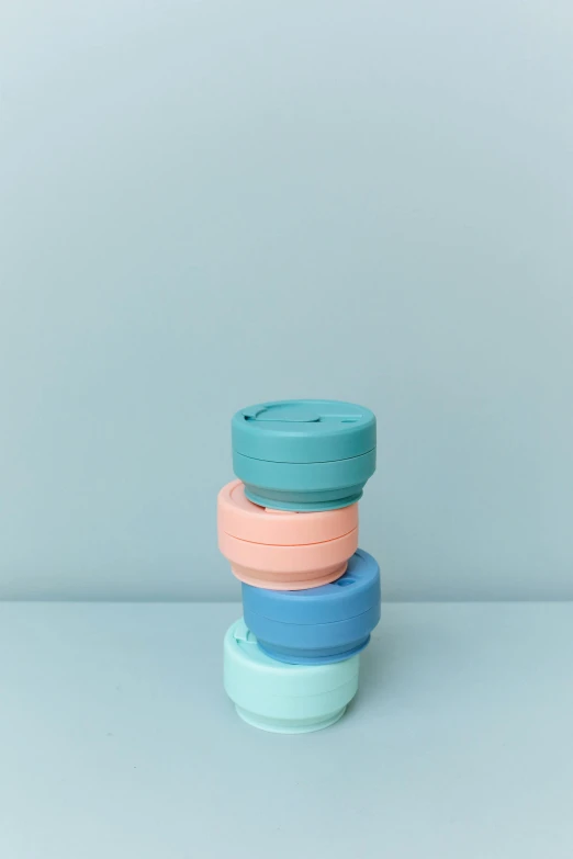 a stack of three cups sitting on top of each other, by Nicolette Macnamara, pexels, minimalism, silicone cover, soft cool colors, 3/4 front view, small