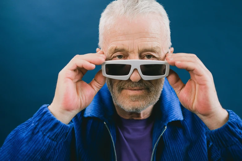 an old man has sunglasses up to his eye
