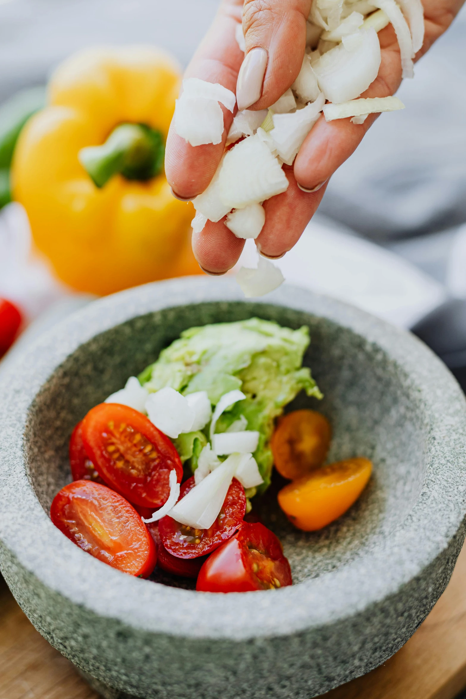 a person sprinkling onions into a bowl of vegetables, by Elizabeth Durack, unsplash, mozzarella, salsa tricks, detail shot, detailed product image