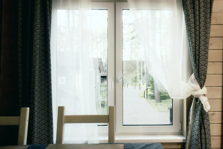 a wooden chair sits in front of a window