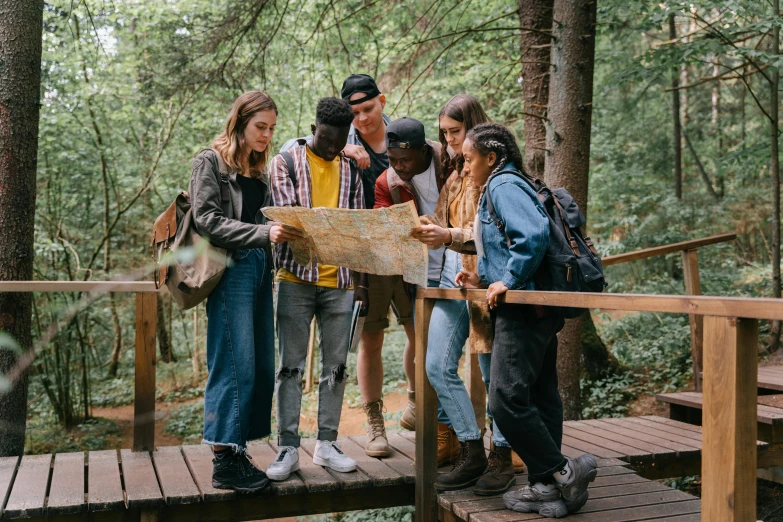 a group of people standing on a bridge looking at a map, trending on pexels, renaissance, forest picnic, avatar image, school class, brown