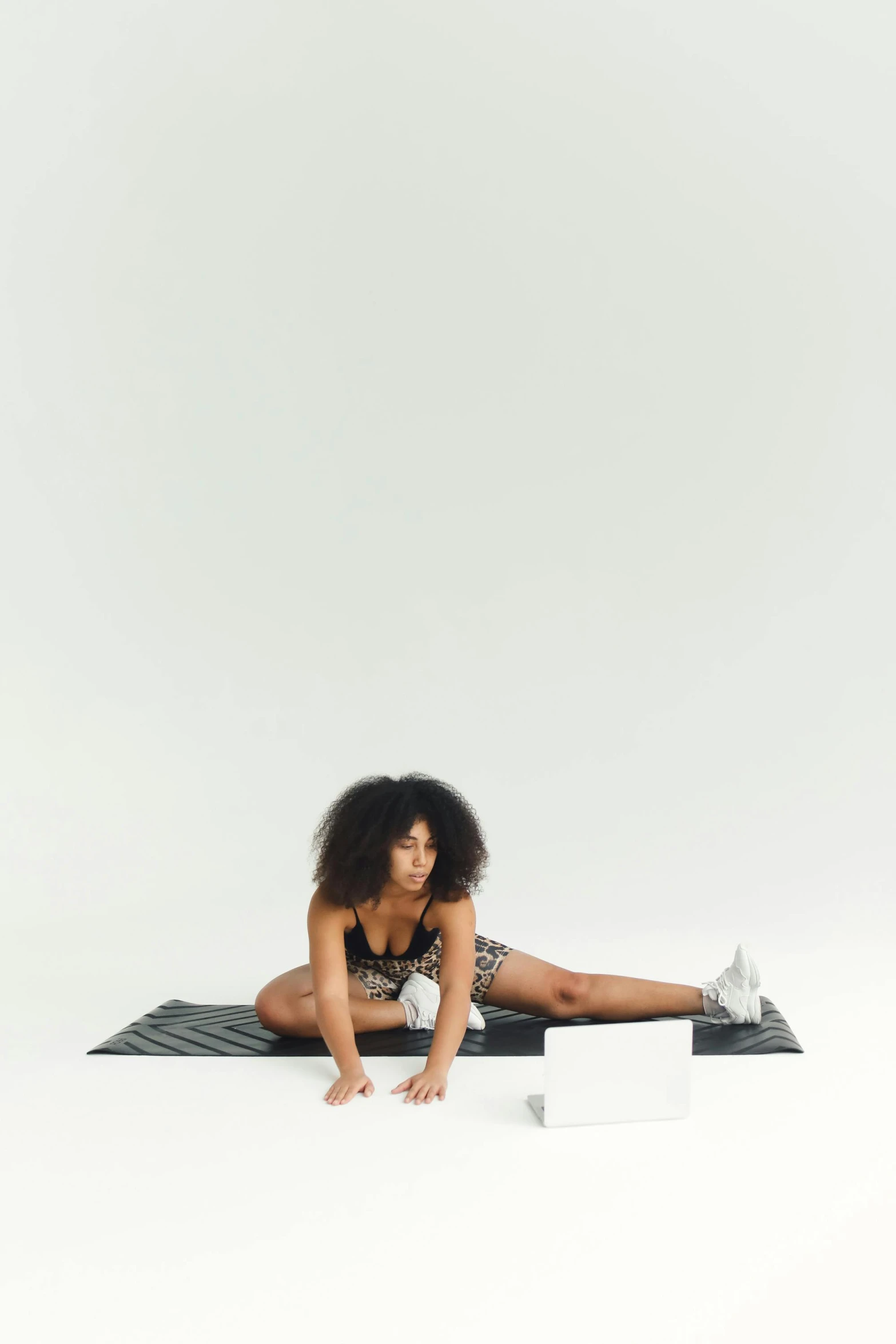 a woman sitting on top of a yoga mat, an album cover, black on white background, working out, full res, dwell