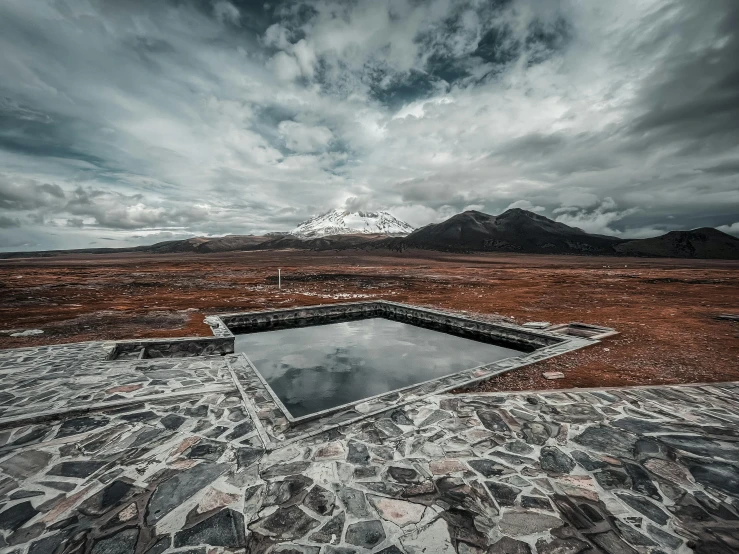 an empty swimming pool sits in the middle of a barren landscape