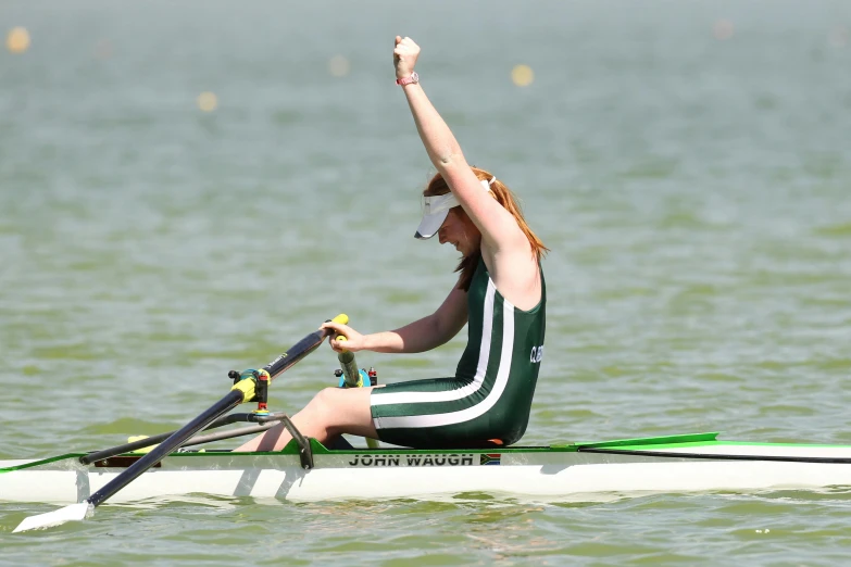 a woman rowing on top of a boat in the water