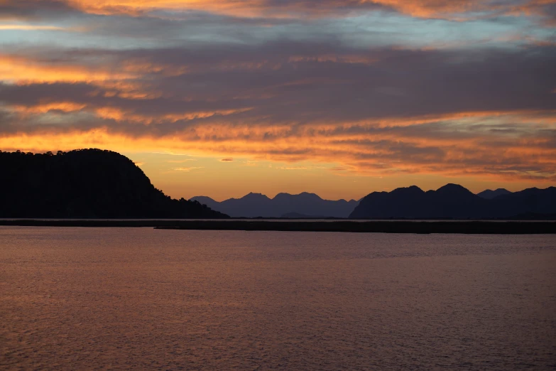 a large body of water with mountains in the background, by Kristin Nelson, pexels contest winner, hurufiyya, colours of the sunset, fjord, thumbnail, brown