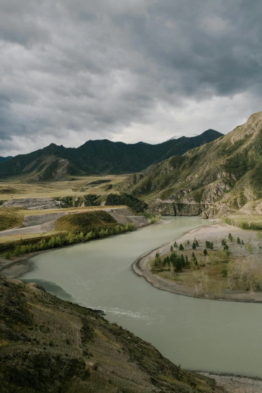 the river is still green and calm among the mountains