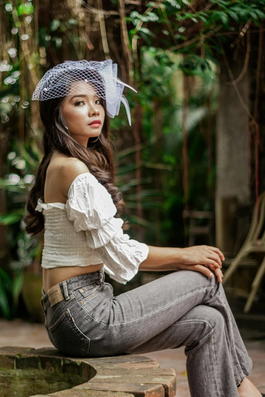a woman sitting on a bench in a garden, inspired by Juan Luna, pexels contest winner, crop top, casual pose, girl with a birdcage on her head, in style of lam manh