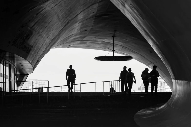 a black and white photo of a group of people, unsplash contest winner, modernism, zeppelin dock, rounded ceiling, man walking, silhuette