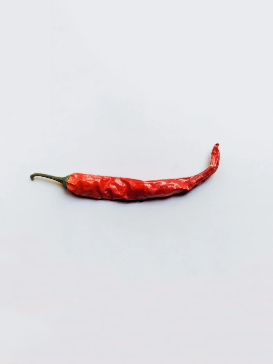 a red chili sitting on top of a white surface, by Gavin Hamilton, unsplash, process art, ignant, hanging, detailed product image, multiple stories