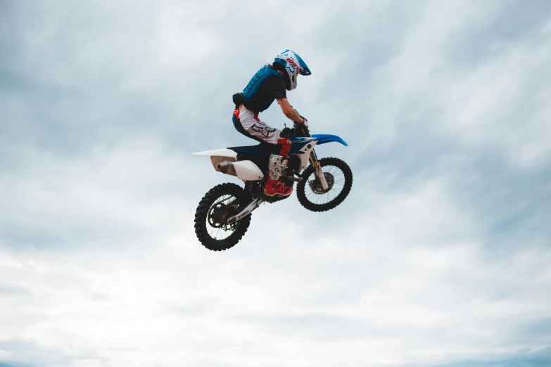 a man flying through the air while riding a dirt bike, pexels contest winner, figuration libre, avatar image, waist high, blue, instagram story