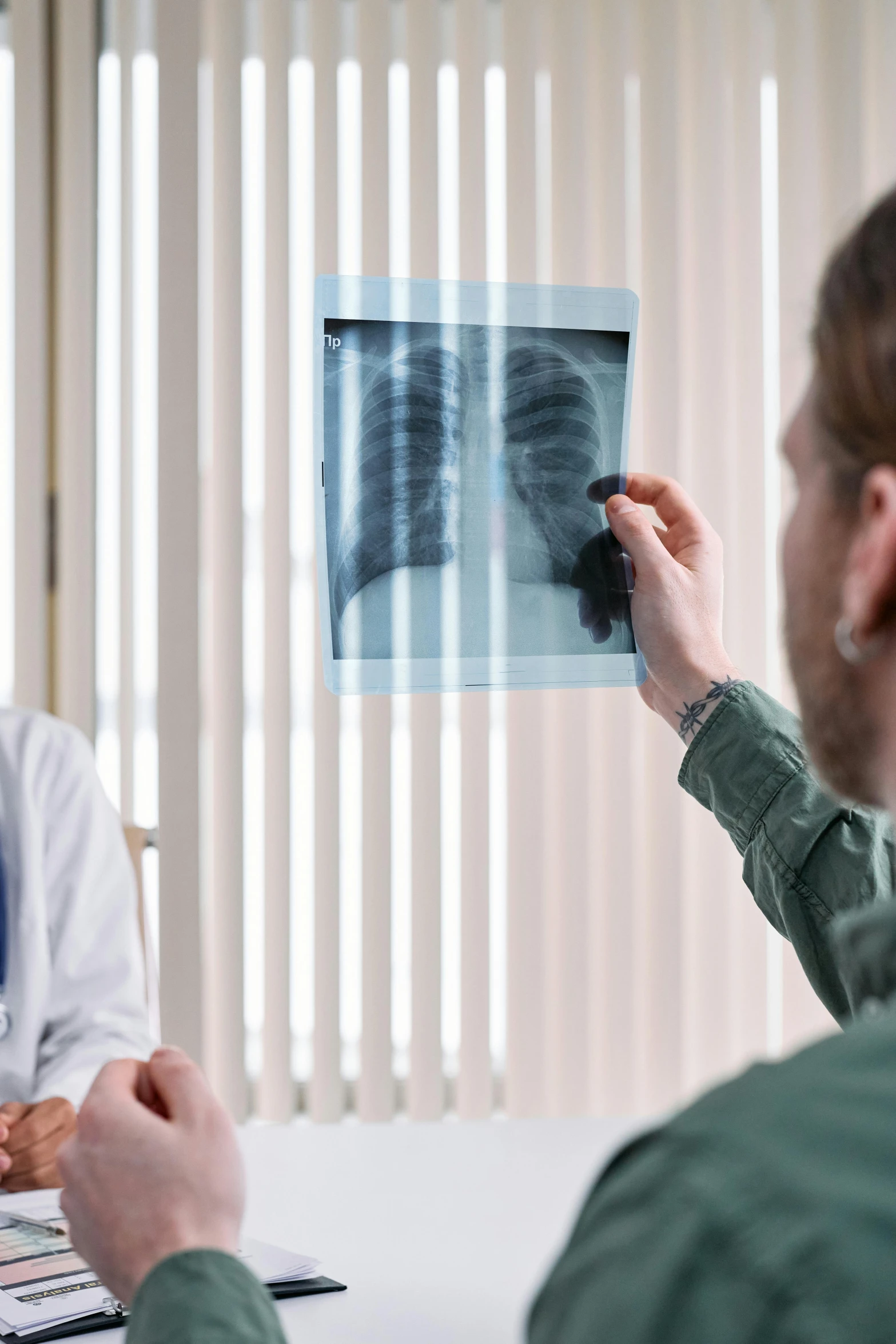 a doctor showing an x - ray to a patient, a picture, by Adam Marczyński, shutterstock, black lung detail, haze over the shoulder shot, 15081959 21121991 01012000 4k, instagram post