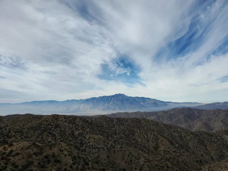 a mountain is pictured during the day with cloudy skies