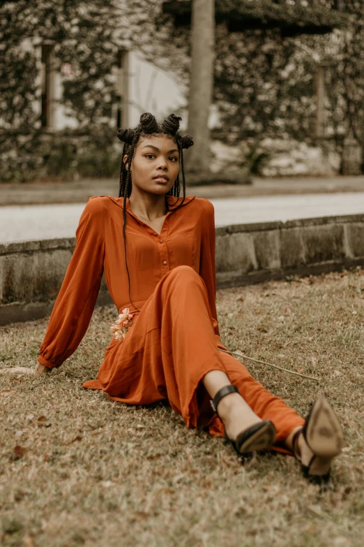 a woman sitting on the ground in an orange dress, trending on pexels, renaissance, dark skinned, southern gothic, fashion editorial, dressed with long fluent clothes