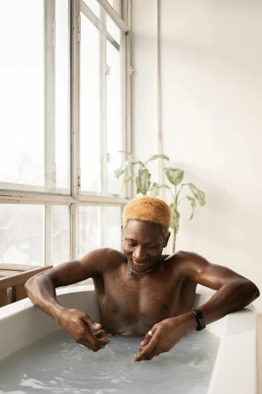 a man sitting in a bathtub with a towel on his head, trending on unsplash, process art, short blonde afro, wholesome, of a shirtless, long boi