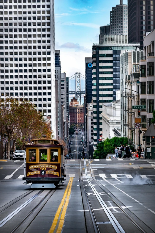 a cable car traveling down a city street, a colorized photo, by Brian Thomas, pexels contest winner, square, bay area, skyscrapers in the distance, conde nast traveler photo