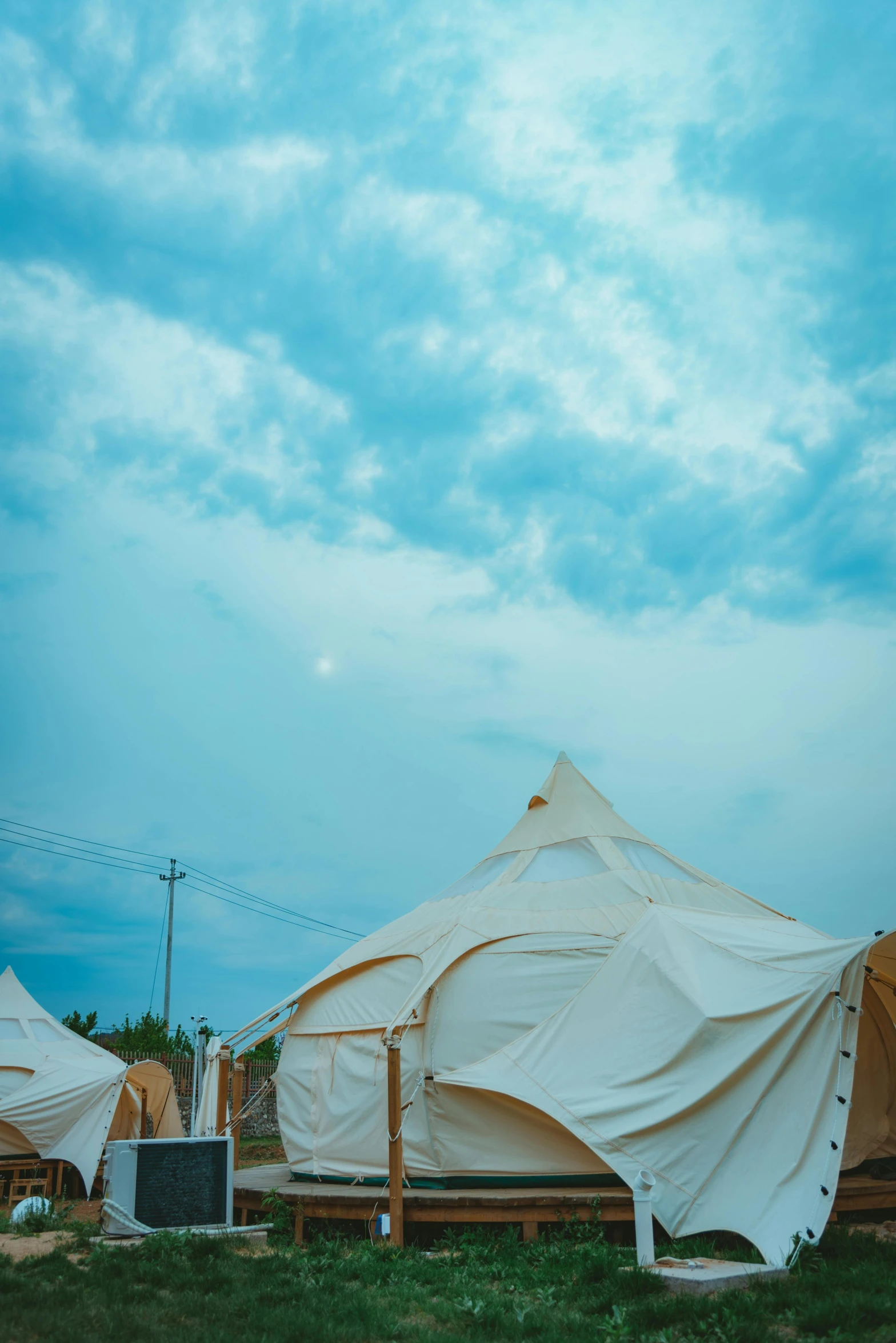 a group of tents sitting on top of a lush green field, sky town, vintage vibe, exterior view, featured