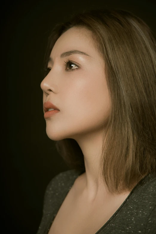 a woman standing in front of a black background, an album cover, inspired by Xia Shuwen, unsplash, hyperrealism, elegant profile posing, portrait of zelda, headshot profile picture, on grey background