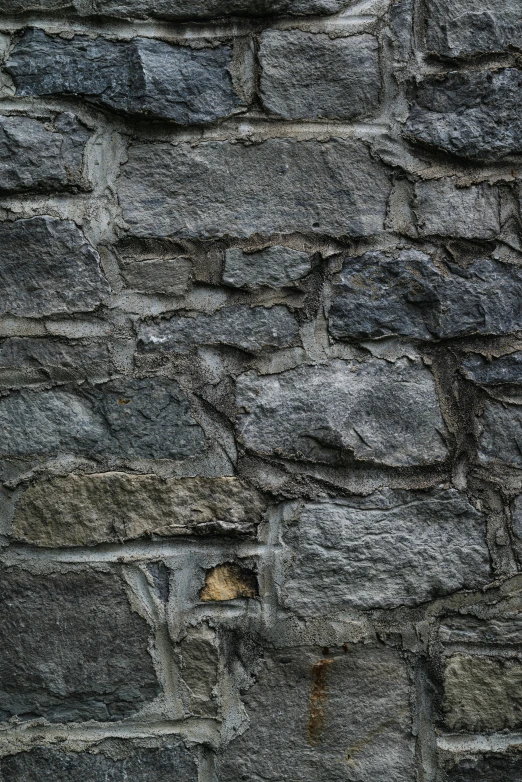 the dark gray stone wall is made of various blocks