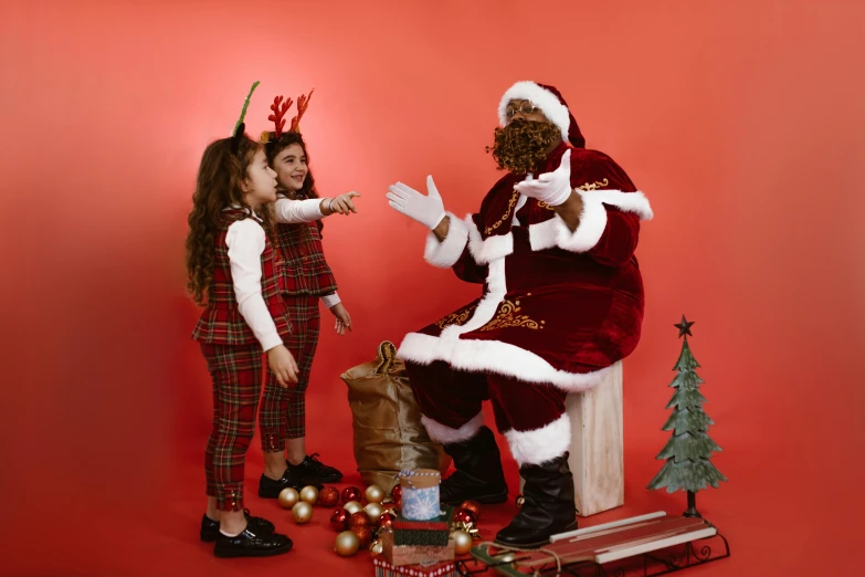 the little girl and santa clause are standing near a chimney