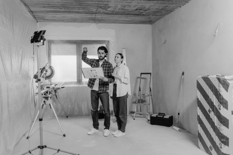 a black and white photo of two people in a room, arbeitsrat für kunst, commercial photo shoot, live action movie, construction, pixar portrait 8 k photo