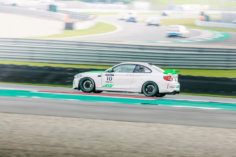 white car driving around the track during a race