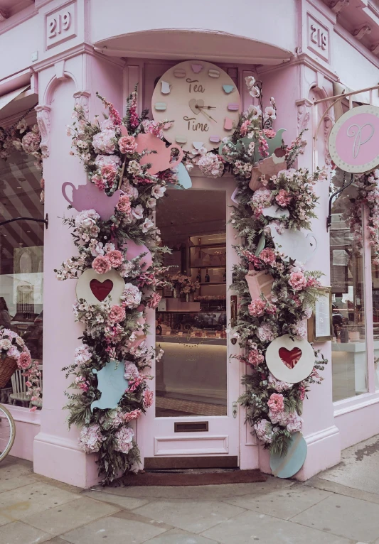 a pink store with a bicycle parked in front of it, heart made of flowers, alice in wonderland theme, instagram story, tea