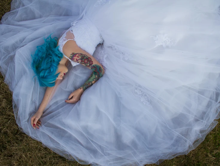 a woman in a wedding dress laying on the ground, a tattoo, inspired by Elsa Bleda, pexels contest winner, pop surrealism, sky blue hair, heartbreak, full colour, waking up