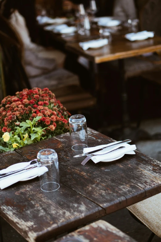 a table that has a bunch of place settings on it, unsplash, renaissance, in a sidewalk cafe, wilted flowers, tavern, fall