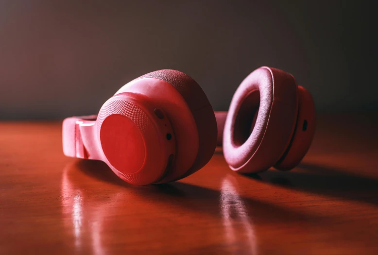 a pair of headphones sitting on top of a wooden table, by Adam Marczyński, trending on pexels, hyperrealism, pink and red color scheme, silicone skin, thumbnail, red hairband