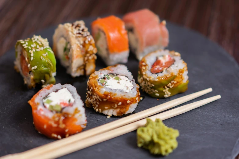 many sushi on a plate with chopsticks