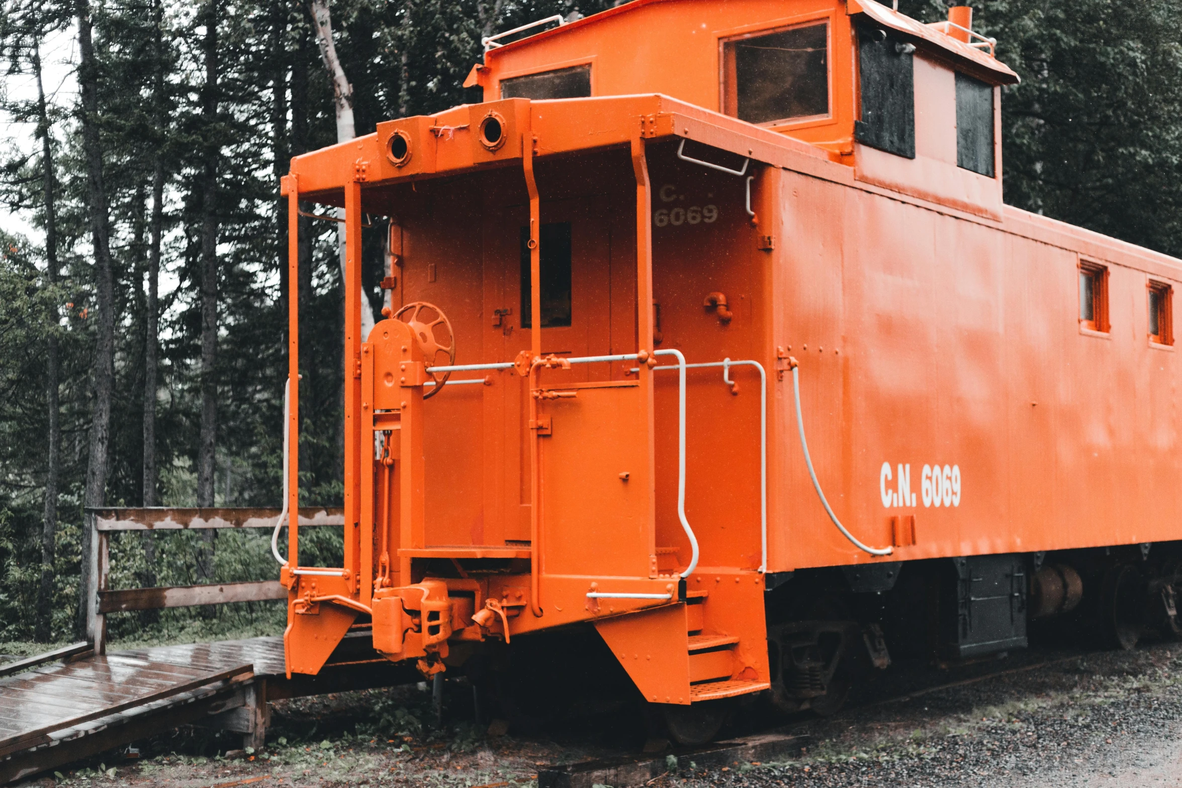 an orange caboose sitting on top of a train track, a portrait, unsplash, 🚿🗝📝, profile image, under repairs, colorized photo