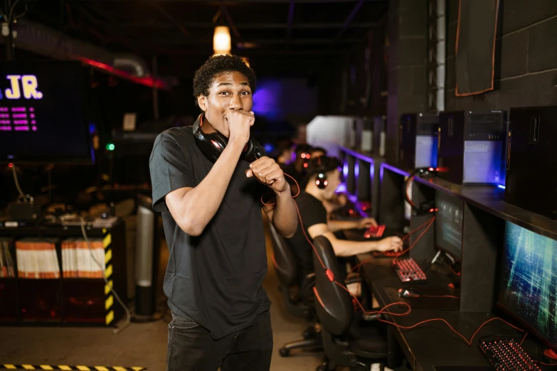 a man that is standing in front of a computer, the video game, hand over mouth, performing, tournament