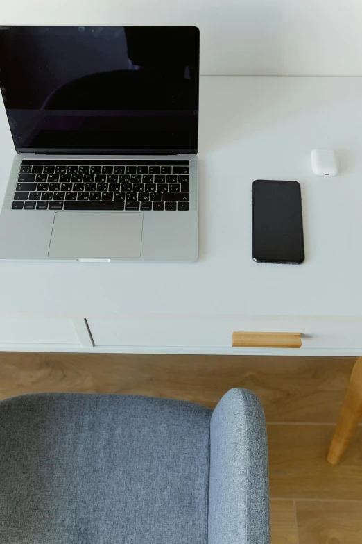 a laptop computer sitting on top of a white desk, unsplash, dwell, satisfying cable management, tables, distant photo