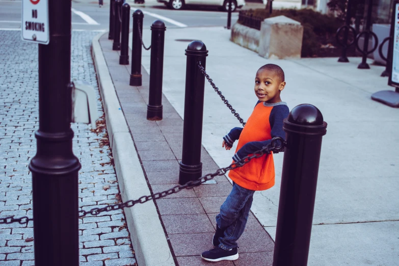 a young boy is chained to a pole, inspired by Gordon Parks, pexels contest winner, orange safety vest, toddler, jemal shabazz, modeling