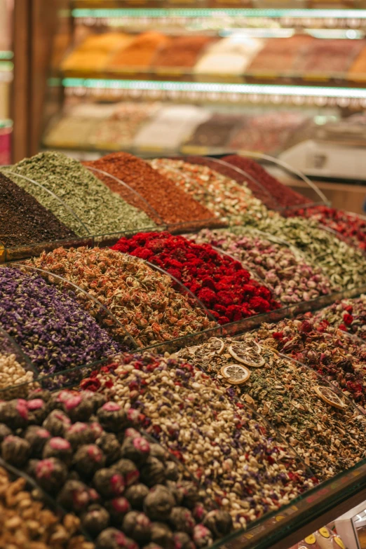 a display case filled with lots of different types of spices, purple and red flowers, inside an arabian market bazaar, instagram post, sprawling